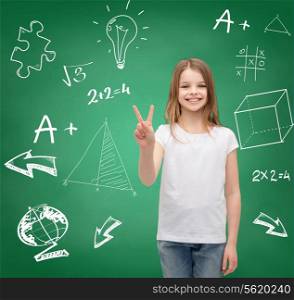 school, childhood, gesture and education concept - smiling little girl in white blank t-shirt showing victory sign