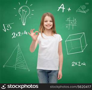 school, childhood, gesture and education concept - smiling little girl in white blank t-shirt showing ok sign