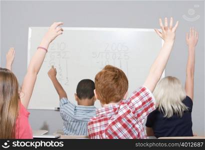 School children raising their hands
