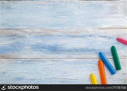 school children&rsquo;s concept. colored pencils and crayons on a blue and white scuffed vintage wooden background. the view from the top. Flat lay