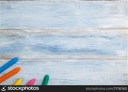 school children&rsquo;s concept. colored pencils and crayons on a blue and white scuffed vintage wooden background. the view from the top. Flat lay