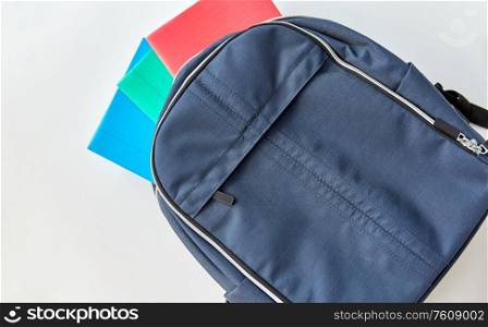 school, education and learning concept - backpack with notebooks on table. school backpack with notebooks on table