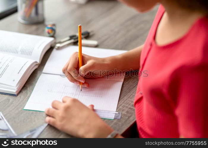 school, education and learning concept - close up of student teenage girl with ruler and pencil drawing line in notebook at home. student with ruler and pencil drawing in notebook