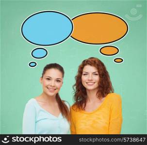 school, education, communication and people concept - smiling student girls over green board background with text bubbles