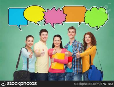 school, education, communication, gesture and people concept - group of smiling students with folders and school bags showing thumbs up over green board background with text bubbles
