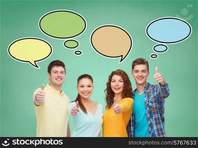 school, education, communication, gesture and people concept - group of smiling teenagers showing thumbs up over green board background with text bubbles