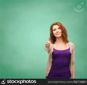 school, education, gesture and people concept - smiling teenage girl in casual clothes showing thumbs up over green board background