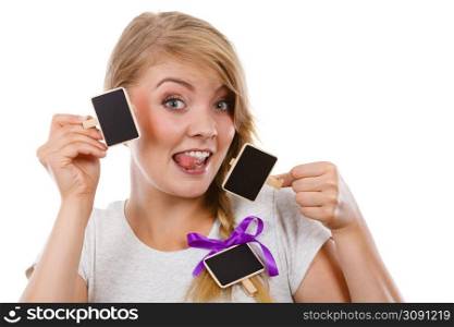 School, education, learning concept. Teenage girl holding little school blackboards and ticking her tongue out. Studio shot on white background.. Teenage girl holding little school blackboards