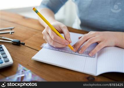 school, education, people and learning concept - close up of student or woman hands with ruler and pencil drawing line in notebook