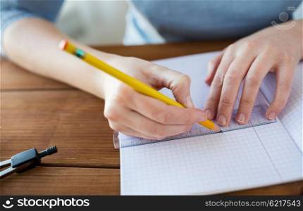 school, education, people and learning concept - close up of student or woman hands with ruler and pencil drawing line in notebook