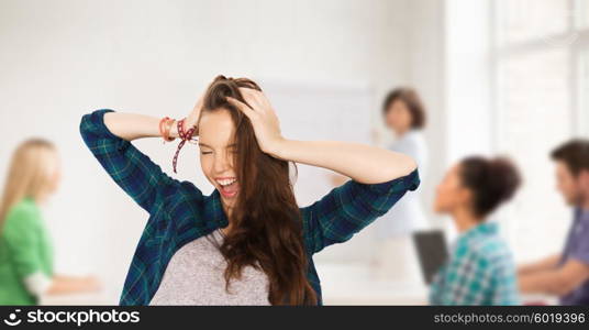 school, education, people and teens concept - happy pretty teenage student girl holding to head over classroom background with teacher and classmates