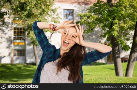 school, education, people and teens concept - happy smiling pretty teenage student girl making face and having fun over summer campus background