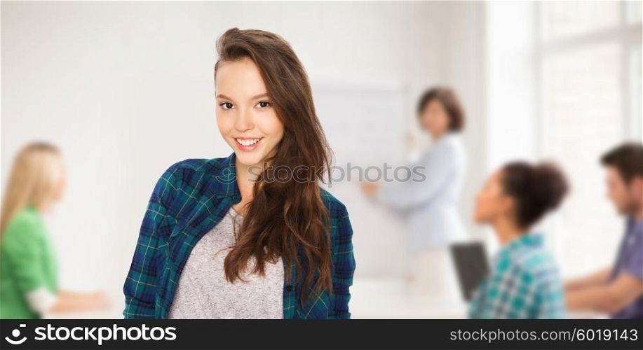 school, education, people and teens concept - happy smiling teenage student girl over classroom background with teacher and classmates
