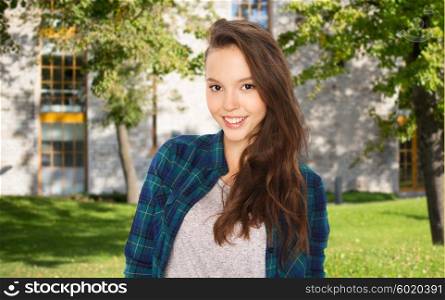 school, education, people and teens concept - happy smiling teenage student girl over summer campus background