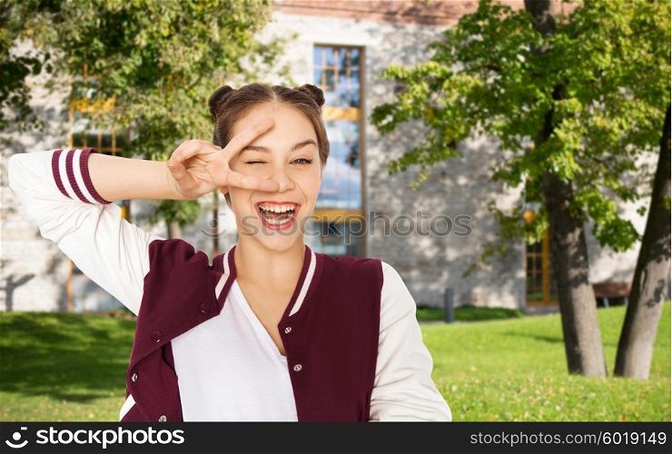 school, education, people, gesture and teens concept - happy smiling pretty teenage student girl showing peace sign and winking over summer campus background