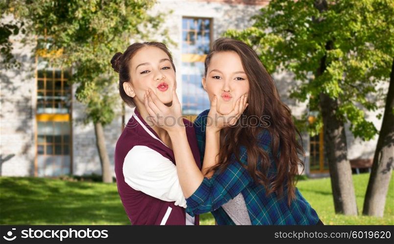 school, education, people, teens and friendship concept - happy smiling pretty teenage student girls having fun and making faces over summer campus background