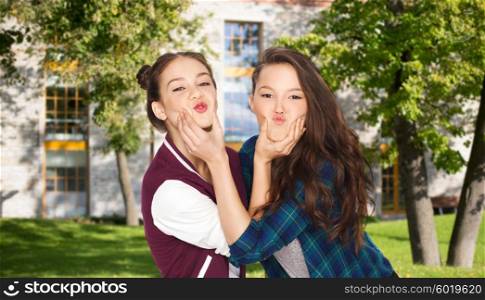 school, education, people, teens and friendship concept - happy smiling pretty teenage student girls having fun and making faces over summer campus background