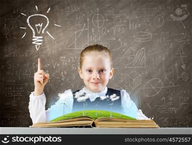 School education. Schoolgirl at lesson looking in opened book