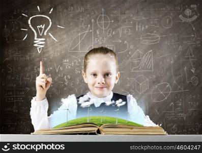 School education. Schoolgirl at lesson looking in opened book