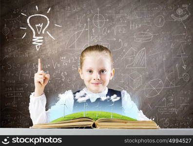 School education. Schoolgirl at lesson looking in opened book