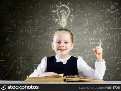 School education. Schoolgirl at lesson with opened book against sketch background