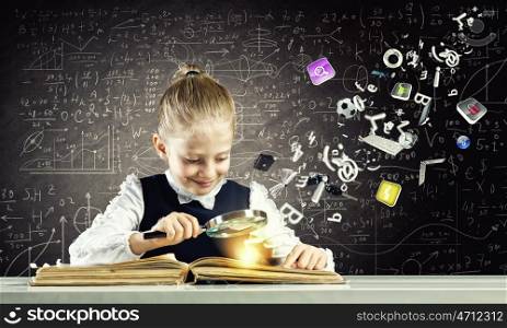 School education. Schoolgirl examining opened book with magnifying glass