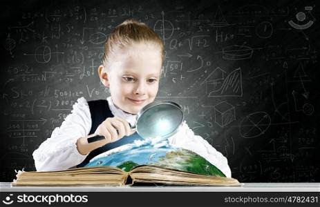 School education. Schoolgirl examining opened book with magnifying glass. Elements of this image are furnished by NASA