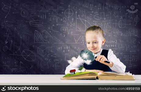 School education. Schoolgirl examining opened book with magnifying glass