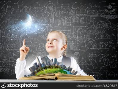School education. Schoolgirl looking in opened book with sketches at background. Elements of this image are furnished by NASA