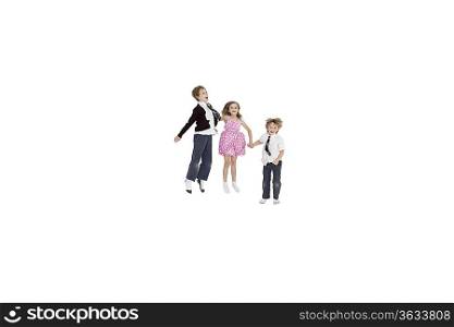 School friends holding hands while jumping over white background