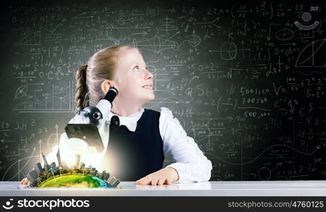 School girl at lesson. Cute girl with microscope against blackboard. Elements of this image are furnished by NASA