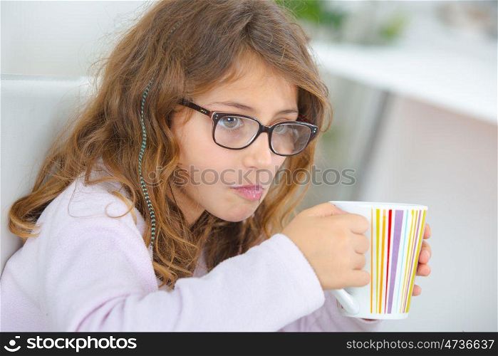 School girl holding stripy cup