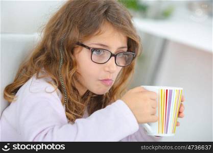 School girl holding stripy cup