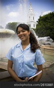 School girl in center plaza by fountain
