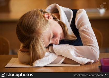 School Girl is sleeping on the desk at the boring lesson