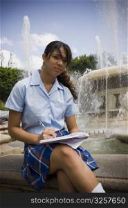School girl sitting in center plaza by fountain
