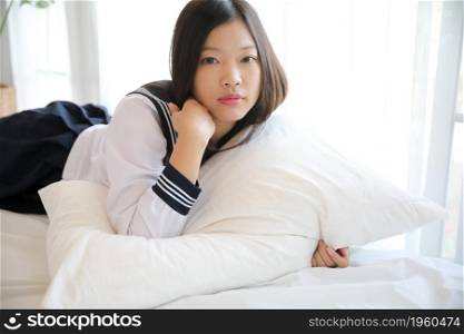 school girl sleeping on bed in white tone bedroom