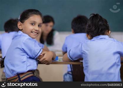 school girl smiling while teacher is sitting in class