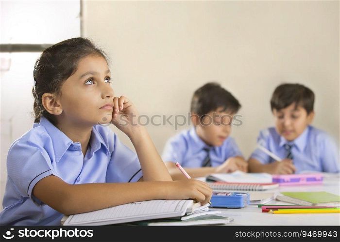 school girl thinking about something while studying in class