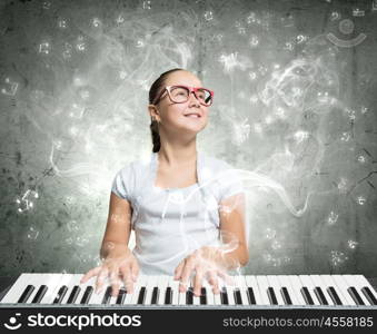 School girl with piano. Pretty school girl in funny glasses playing piano