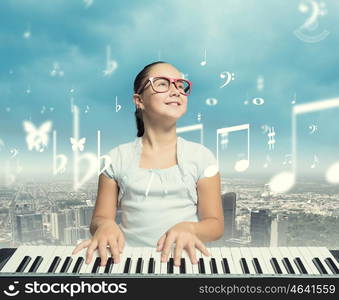 School girl with piano. Pretty school girl in funny glasses playing piano