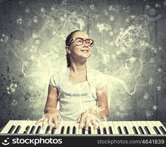 School girl with piano. Pretty school girl in funny glasses playing piano