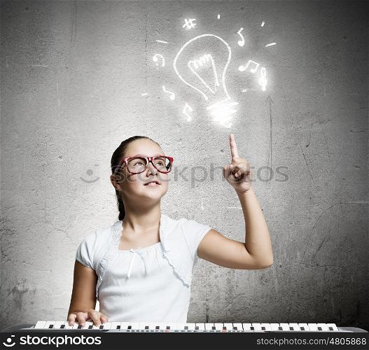 School girl with piano. Pretty school girl in funny glasses playing piano