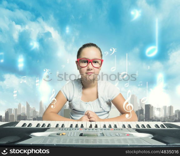 School girl with piano. Pretty school girl in funny glasses playing piano