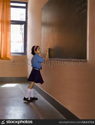 School girl writing on the black board
