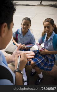 School girls giving phone number to boy