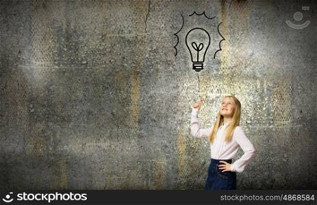 School kid. Cute schoolgirl pointing on electrical bulb with finger