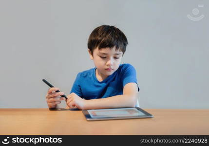 School Kid learning online class room at home, Child using tablet for homework, Young boy studying online video call, E-learning or Homeschooling education concept