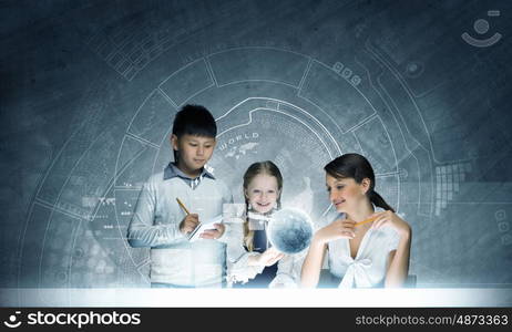 School lesson. Young teacher and school children examining hologram. Elements of this image are furnished by NASA