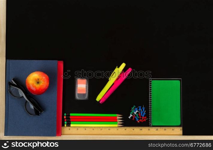 School supplies on blackboard. Back to school concept.